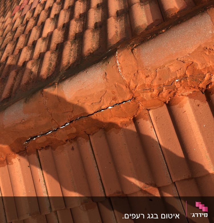 רעפים כתומים עם סדקים ותיקון בטיט על הגג